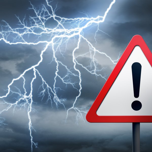Gewitterhimmel mit Blitzen und Warnschild mit Ausrufezeichen